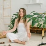 Peaceful meditation scene with a woman practicing mindfulness in a cozy, plant-filled indoor space.